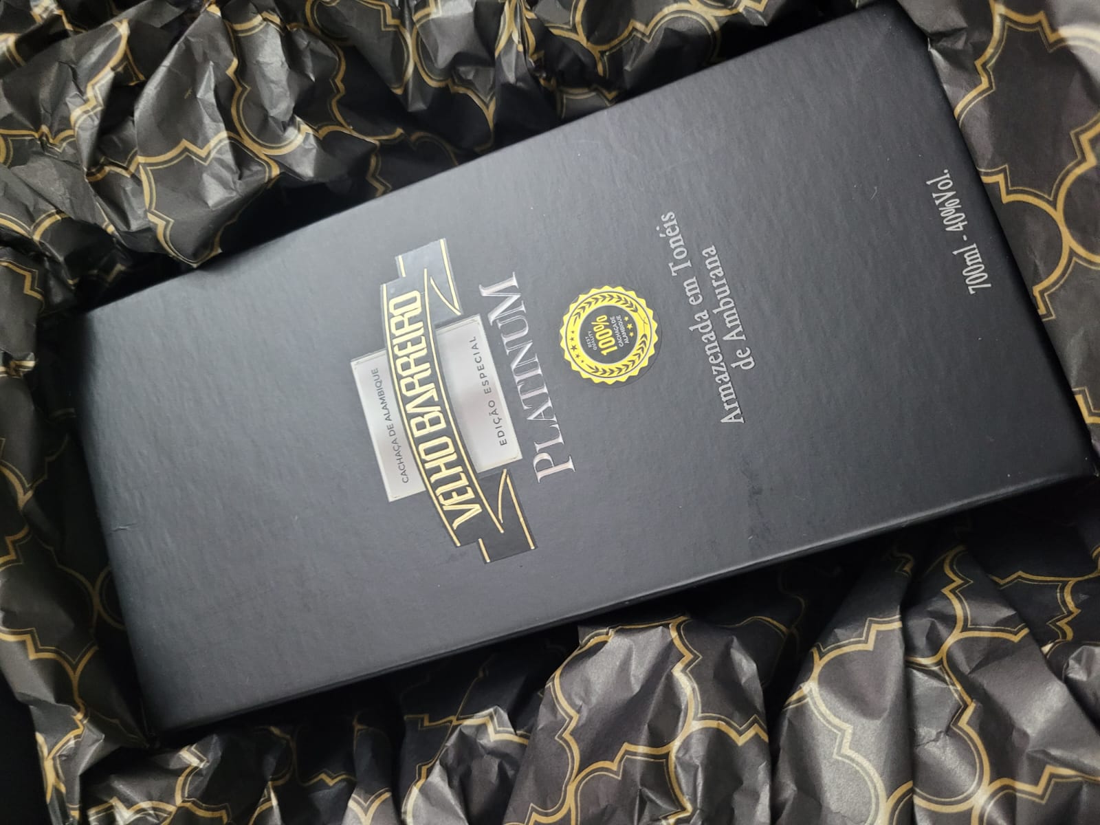 Caixa rígida preta de edição especial sobre papel seda preto e dourado