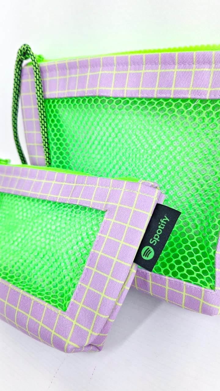 Necessaires exclusivas em tela lilás e malha verde neon com etiqueta Spotify